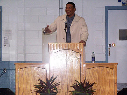 Cam Newton speaking at a podium